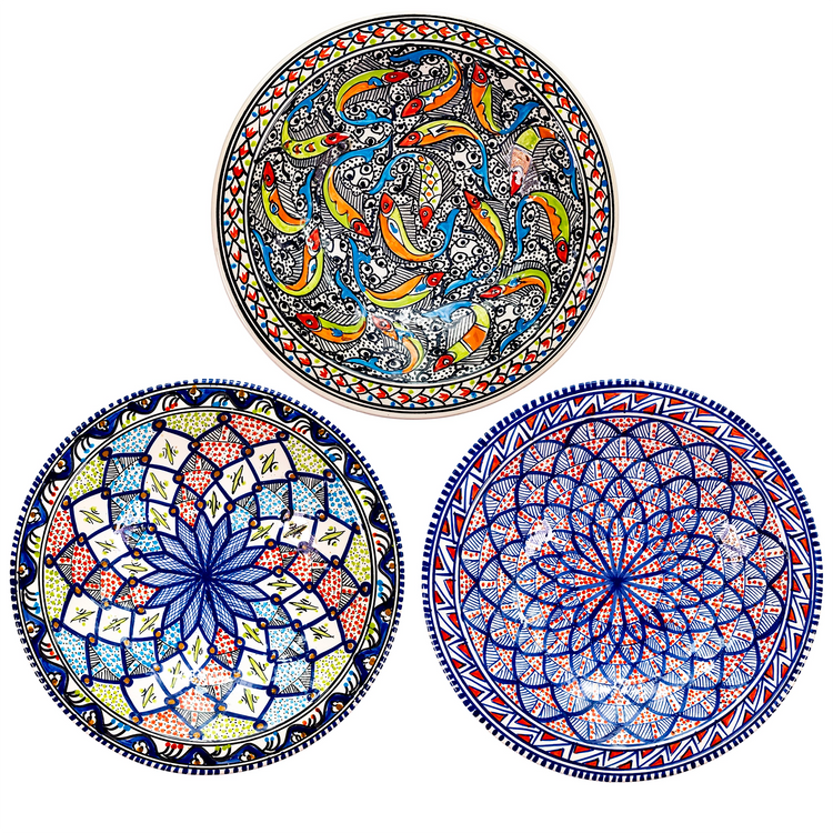 A display of 3 extra large Moroccan style ceramic decorative bowls with sunburst and marine patterns