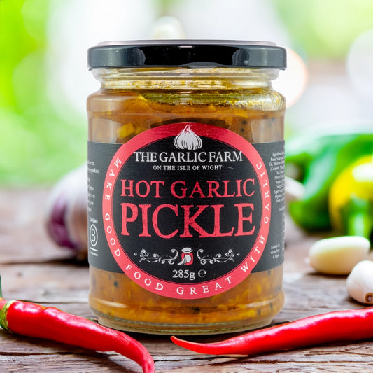 jar of pickle surrounded by chillies and garlic