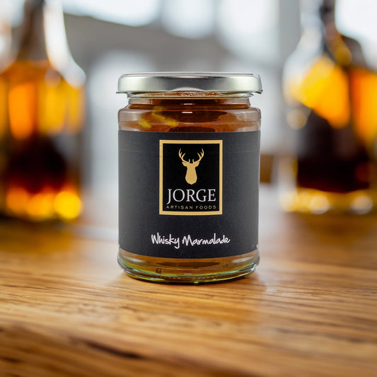 Jorge whiksy marmalade jar on a table with whisky in the background