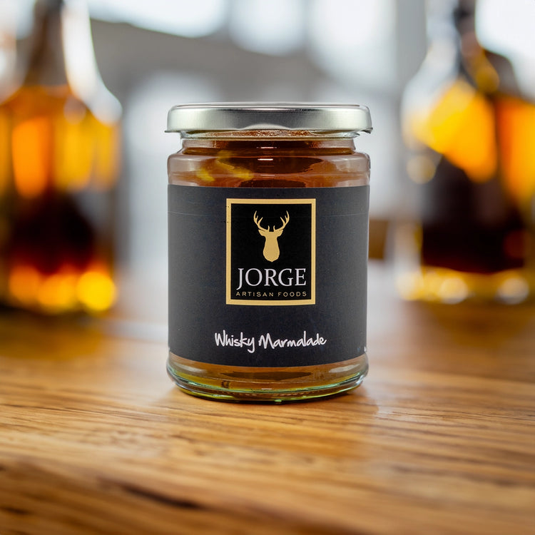 Jorge whiksy marmalade jar on a table with whisky in the background