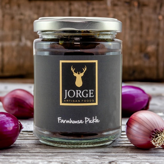 Jorge artisan farmhouse pickle on table surrounded by onions
