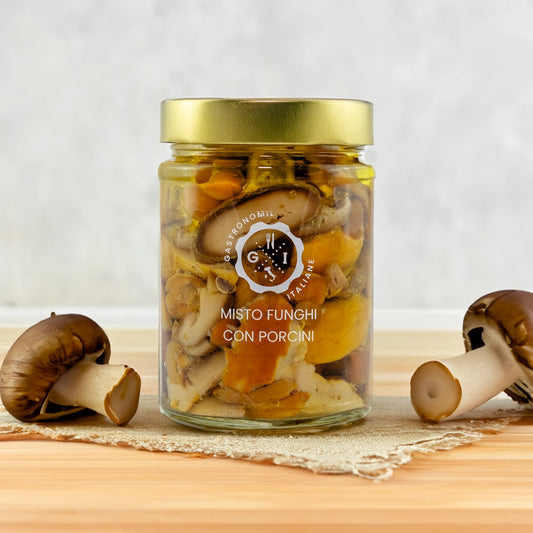 Jar of Misto Funghi with Porcini on wooden table with mushrooms around it