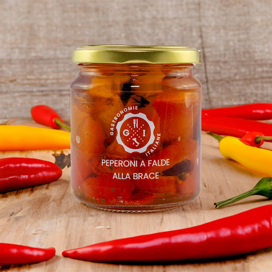 Jar of Preserved Grilled Peppers surrounded by pepper on a wooden table