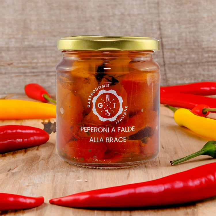 Jar of Preserved Grilled Peppers surrounded by pepper on a wooden table