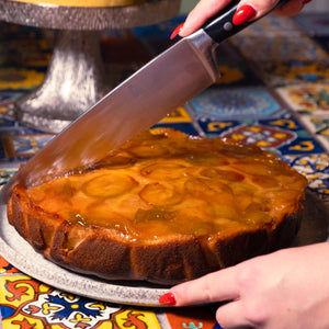 plum cake on a plate being cut with a cake knife in the Jorge's café.