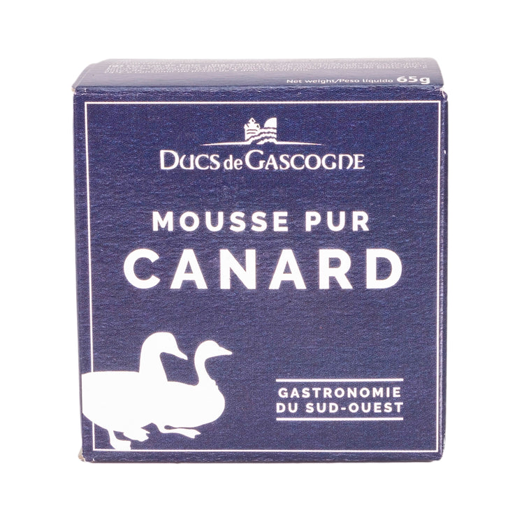 A blue cardboard box featuring two ducks. The label reads "Ducs de Gascogne Mousse Pur Canard Gastronomie du Sud-Ouest" in French, which translates to "Dukes of Gascony: Pure Duck Mousse Gastronomy of the Southwest."