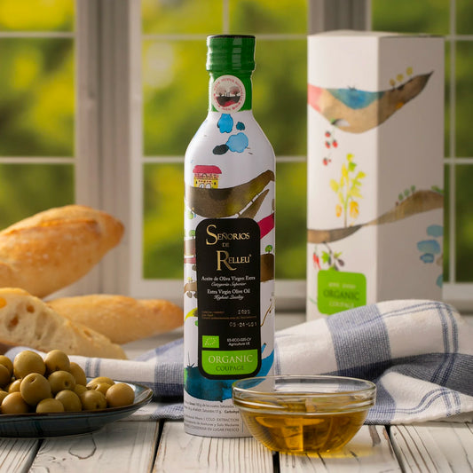 Senorios de Relleu Organic Extra Virgin Olive Oil on table with olives and breads