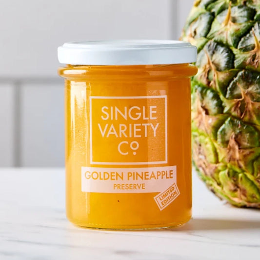 jar of single variety pineapple preserve sat next to a pineapple