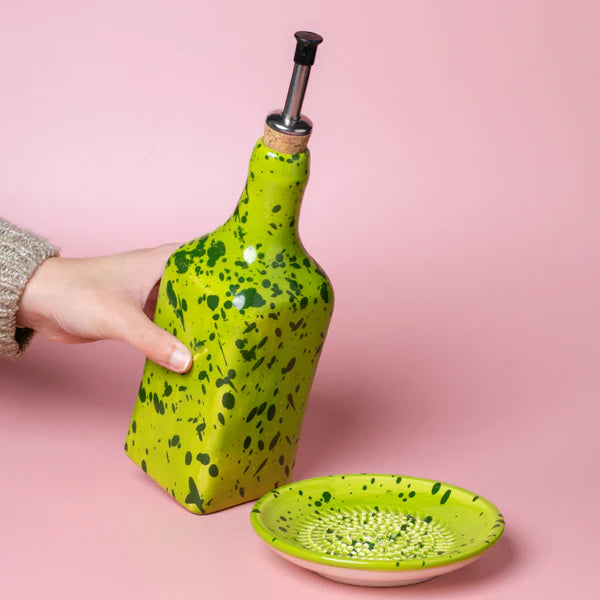 Tierra Cocida bright green handmade oil pourer held in hand with dish