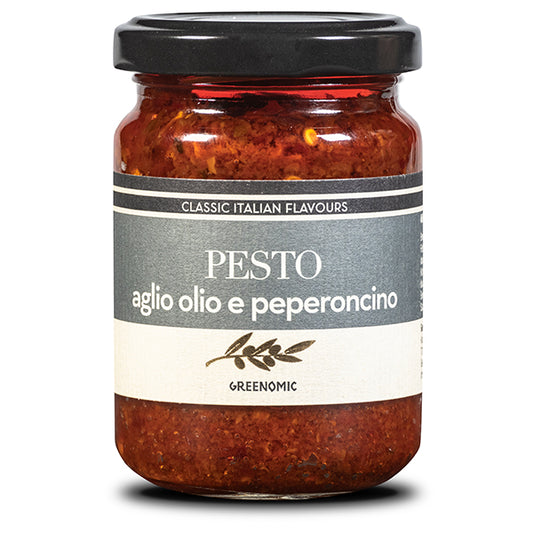 A glass bottle with the Pesto with garlic, oil and chilli pepper inside. On the grey and white label there is an image of a olive branch with Greenomic brand underneath.