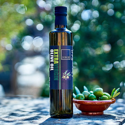 Jorge extra virgin olive oil outdoors with bowl of fresh olives