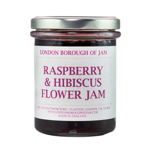 A glass jar of London Borough of Jam Raspberry & Hibiscus Flower Jam. The jar has a silver lid and is filled with a deep red jam.